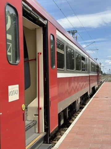 Einstieg in einen roten Reisezugwagen.